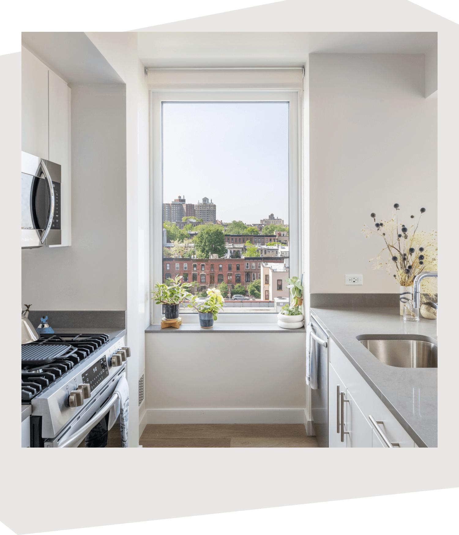 View of a windowed kitchen at 595 Dean St, showing the appliances and the Prospect Heights neighborhood outside.